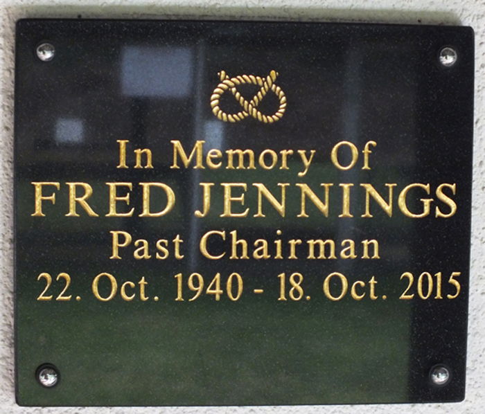 Photograph shows the memorial plaque mounted on the clubhouse wall, dedicated to Fred Jennings, for his dedication to the sport of Smallbore Rifle Shooting.