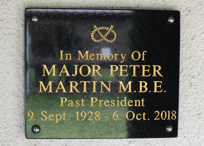 Photograph shows the memorial plaque mounted on the clubhouse wall, dedicated to Major Peter Martin M.B.E.., for his dedication to the sport of Smallbore Rifle Shooting.