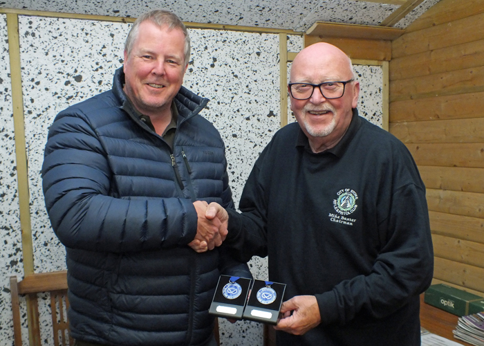 Photograph shows City of Stoke RPC Chairman - Mike Baxter (pictured right) presenting Dom Paskin (pictured left) with his SSRA Individual 10 Metres Air Pistol League 2nd Place Medal, and his SSRA Individual 10 Metres Air Rifle 'B' League 2nd Place Medal.