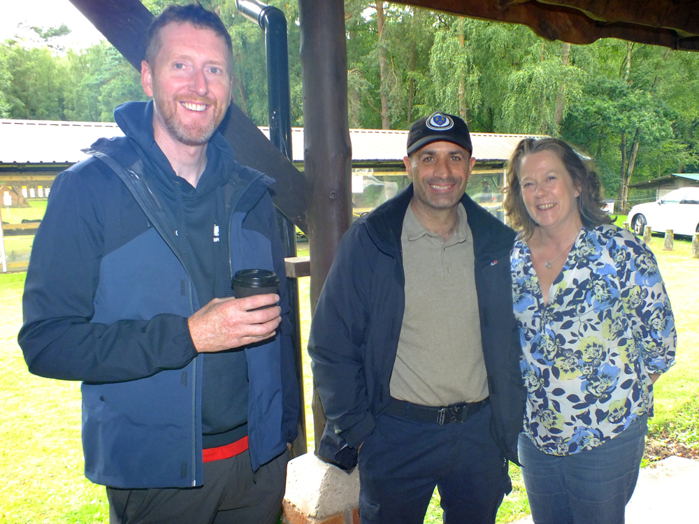 Photograph shows smiles-aplenty on the faces of Simon Green (pictured left), Kosta Loukas (pictured centre) and Dawn Hunt (pictured right) as they relax while sheltering under the clubhouse verandah.