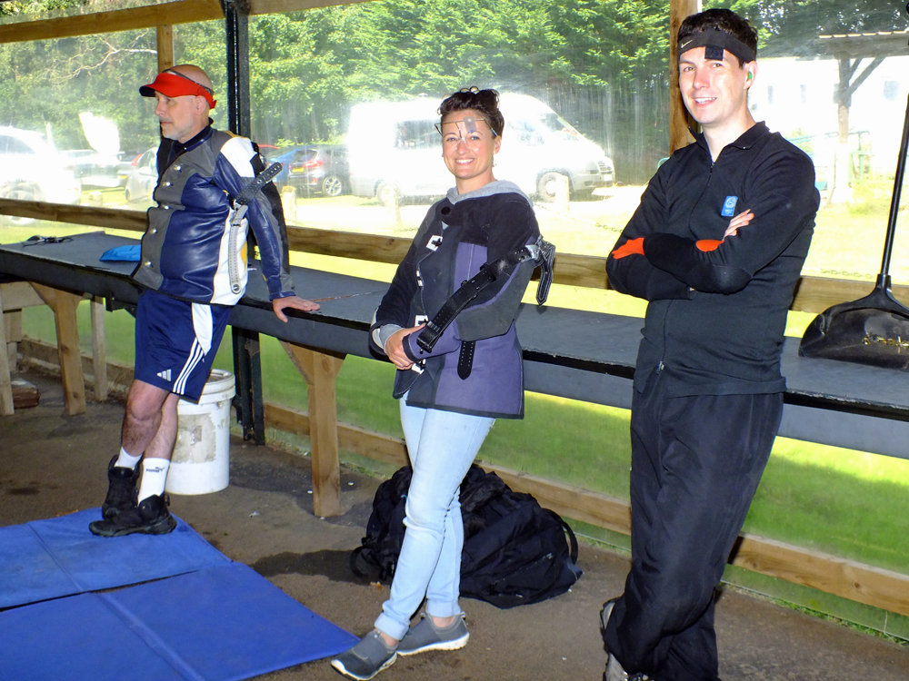 The above photograph shows Gavin Scott-Brooker (pictured left), Natasha Minikin (pictured centre) and Richard Hemingway (pictured right)  relaxing on the firing line before the start of their next detail.