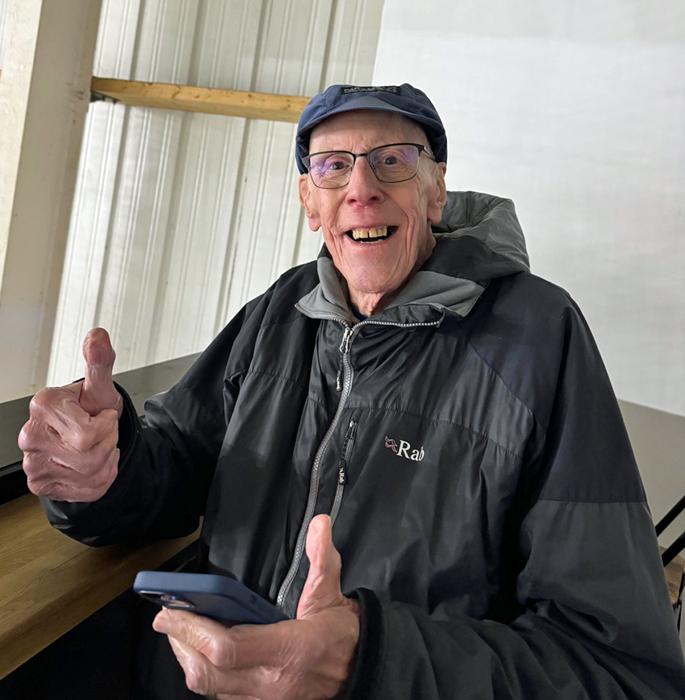 Photograph shows former SSRA President - Robert (Bob) Knott - checking the Chelsea football results, during a break in play in the Ice Hockey game he was watching.  (Photograph kindly submitted by Bob's son, Paul Knott.