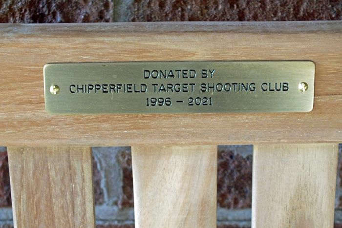Photograph shows the plaque mounted on the bench, and sited on the verandah of the main Clubhouse of the Chipperfield Ranges.
