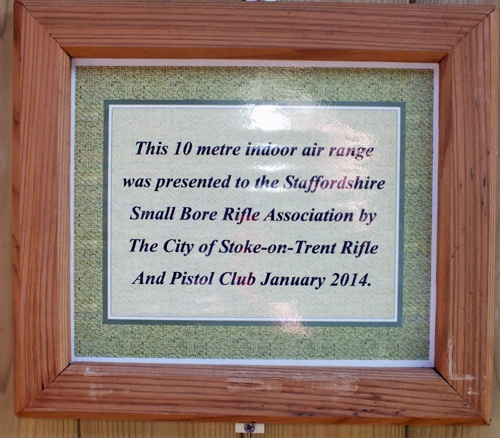 Photograph shows the dedication plaque fixed to the Airgun Range, in appreciation of The City of Stoke-on-Trent Rifle And Pistol Club's very kind gesture of presenting the Indoor 10 Metres Air Weapons Range to the Staffordshire Smallbore Rifle Association in January 2014.