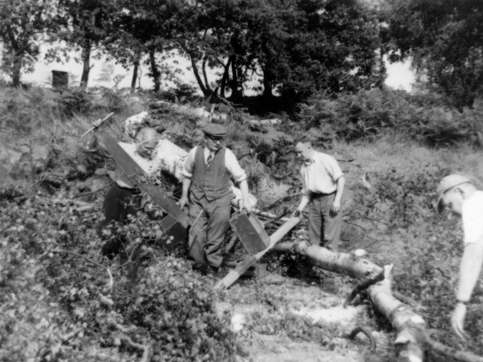 Photograph shows a group of very willing committee members and shooters clearing trees.