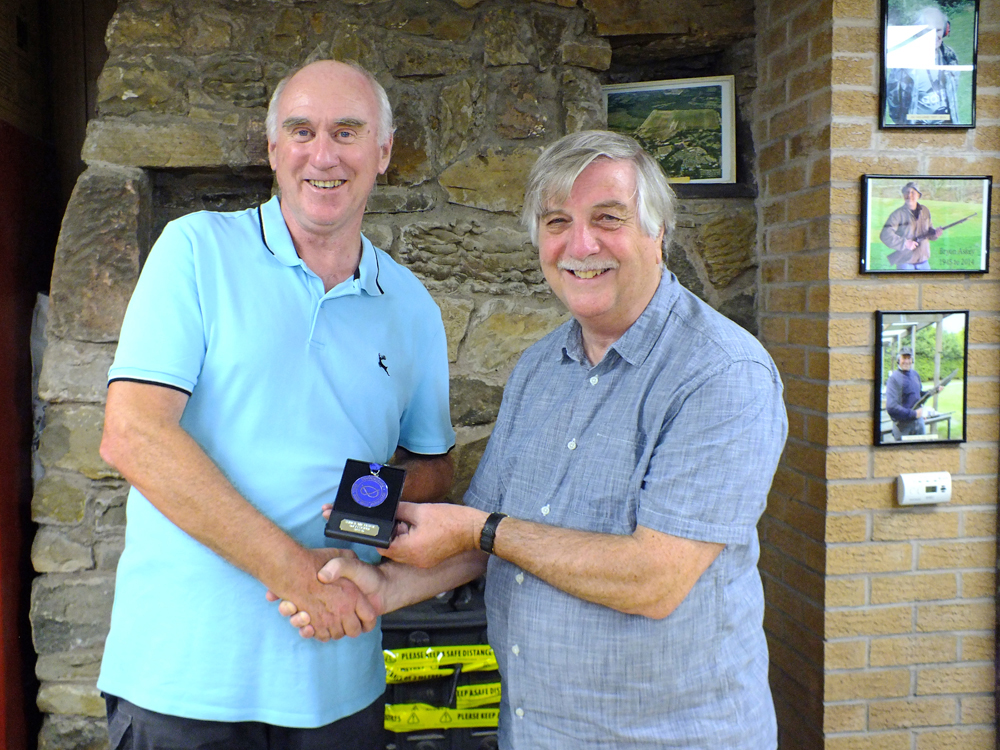 Photograph shows John Cooper of Leek and District SC (pictured left) receiving his SSRA Individual 10 Metres Air Pistol League - Winter 2025/2026 - 2nd Place Medal from Osborn J Spence of Leek and District SC (pictured right).