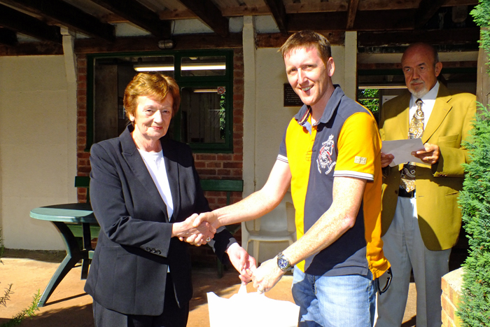 Photograph shows Mary Jennings, pictured left, presenting the Class A 1st Place Prize to Simon Green, pictured right.