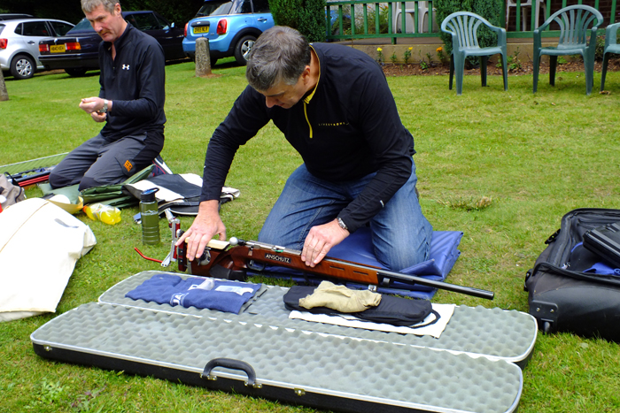 Photograph shows a competitor carefully preparing his Anschutz rifle, prior to competition.