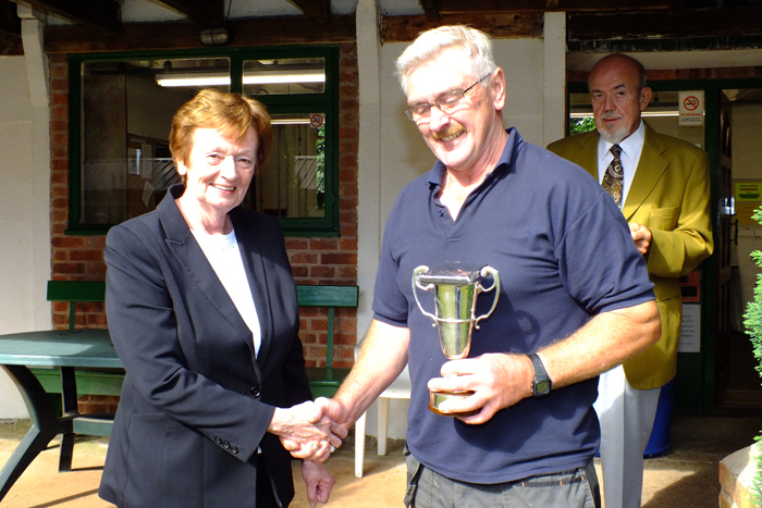 Photograph shows Mary Jennings, pictured left, presenting the Miniature Rifle Cup and 1st Place Medal to Peter Dean, pictured right.