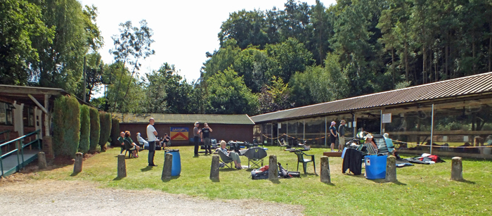 Photograph shows the picturesque ranges in full use by competitors, as others choose to relax in the sunshine between details.