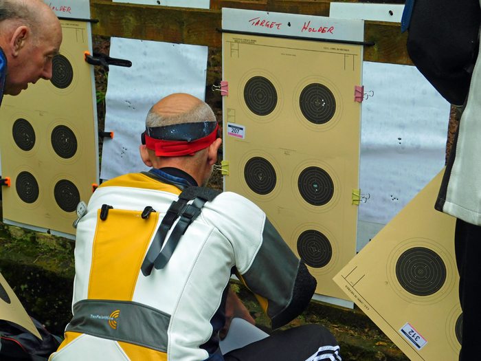 Photograph shows competitors checking their targets at the far end of the range.