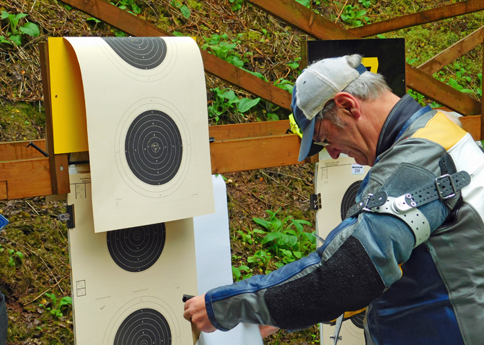 Photograph shows Neil Almond carefully fixing his target to the frame. it's almost as tricky as wallpaper hanging!