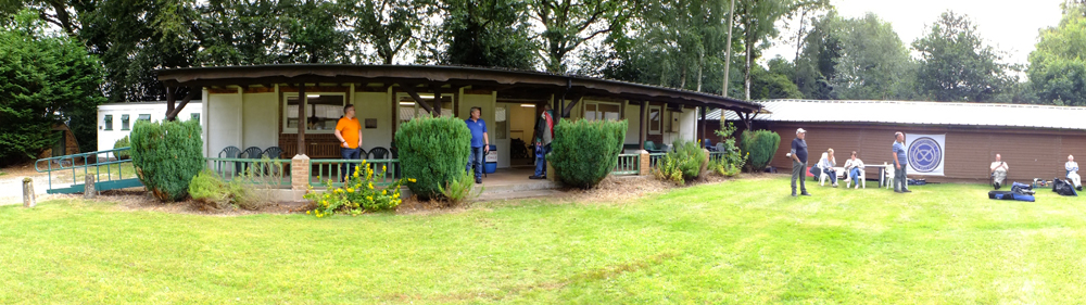 Photograph shows the picturesque setting of the clubhouse, with competitors taking in the ambiance.