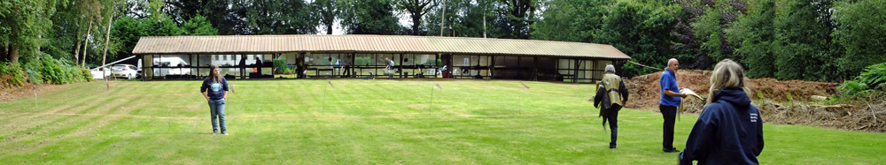 Photograph shows a panoramic view of the competitors taking a leisurely stroll back towards the firing line.