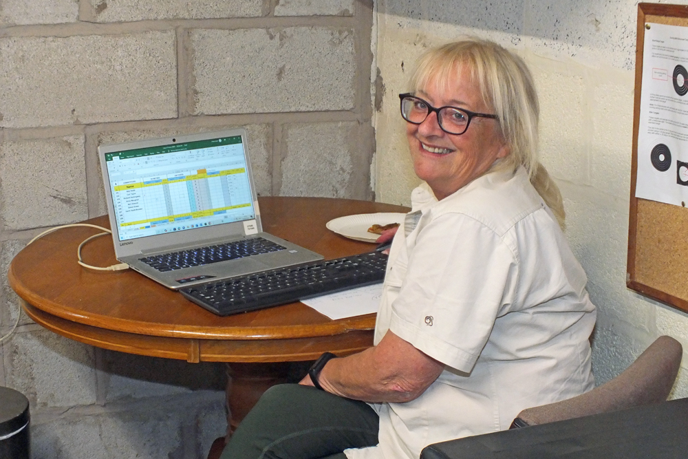 Photograph shows Debbie Round - Scoring Team member - poised at the laptop, ready to enter the official scores onto the computer as they come in.