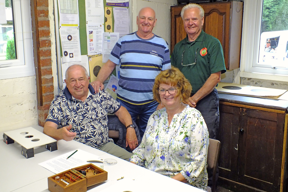 Photograph shows the scoring team of John Wilshaw (seated left), Jeff Hickson (standing left), Tony Errington (standing right), and Judith Simcock (seated right) finally being able to relax after a very busy day's scoring of the targets. Well done to you all!