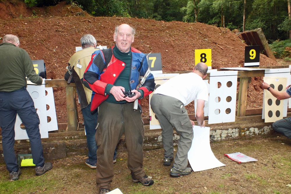 Photograph shows Brian Parker preparing to make his way back to the firing line after swapping his targets.